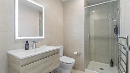 a bathroom with a toilet and a sink and a shower at QV Stays Modern City Apartment in Auckland