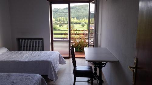 a bedroom with a bed and a table and a window at El Crucero in La Magdalena