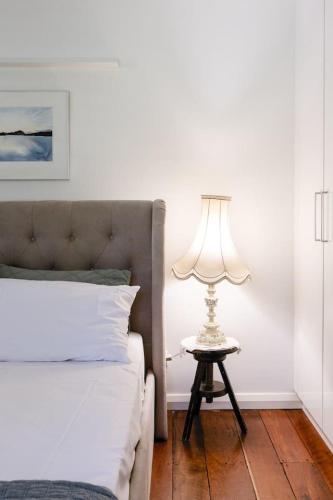 a bedroom with a bed and a table with a lamp at The Farmhouse, elegance in the Margaret River coastal countryside in Rosa Brook