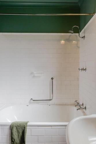 a white bathroom with a tub and a sink at The Farmhouse, elegance in the Margaret River coastal countryside in Rosa Brook