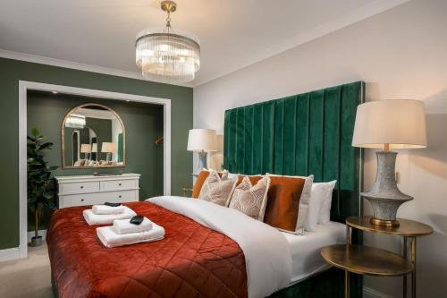 a bedroom with a large bed with a green headboard at Emerald Suite, The Stirling Residence in Stirling
