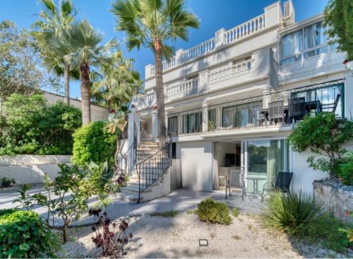 - une vue sur l'extérieur d'une maison blanche avec des palmiers dans l'établissement Luxury villa face to the sea - swimming pool, à Cannes