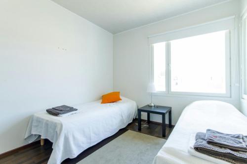 a white room with two beds and a window at Spacious Apartment for 8 with Sauna in Kerava