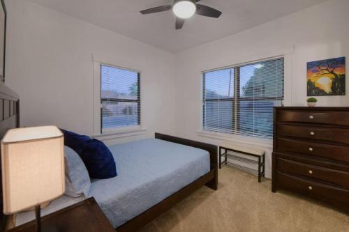 a bedroom with a bed and a dresser and windows at Charming Spanish Style Vintage Casita in Tucson