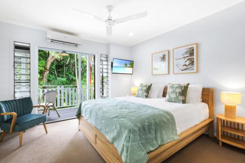 a bedroom with a large bed and a balcony at The Queenslander - Full Moon Terrace in Port Douglas