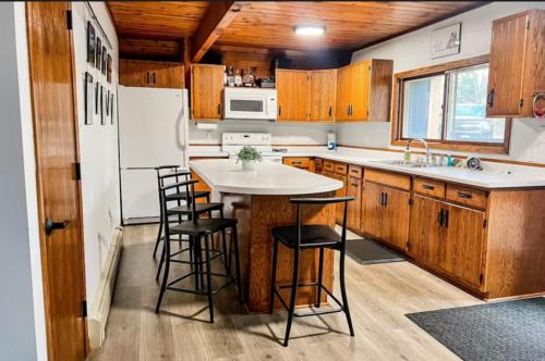 a kitchen with wooden cabinets and a white refrigerator at Tamarack Lodge Tomahawk WI in Lake Tomahawk