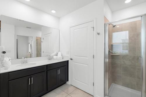 a bathroom with a shower and a sink and a mirror at Paradise Home 20 Mins to Disney with Pool and Waterpark on Property in Abbeyville