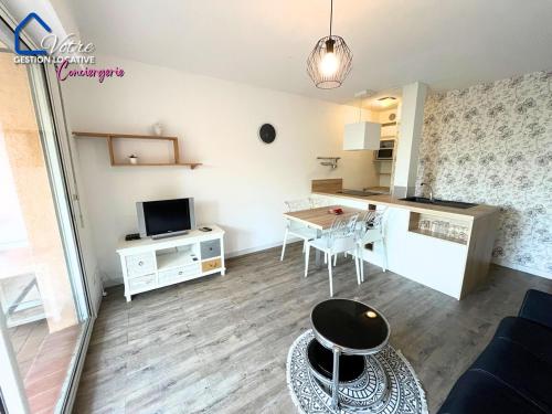 a small living room with a table and a kitchen at L'Empereur Colliourenc in Collioure