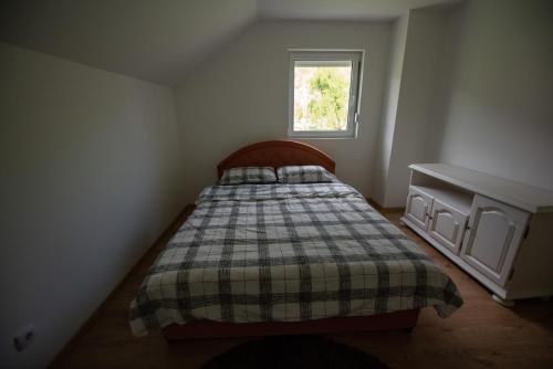 a small bedroom with a bed and a window at Vukota - Kuca za odmor in Plav