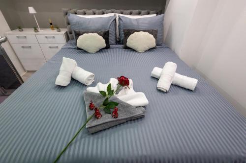 a blue bed with towels and flowers on it at Matija Lux2 in Kraljevo