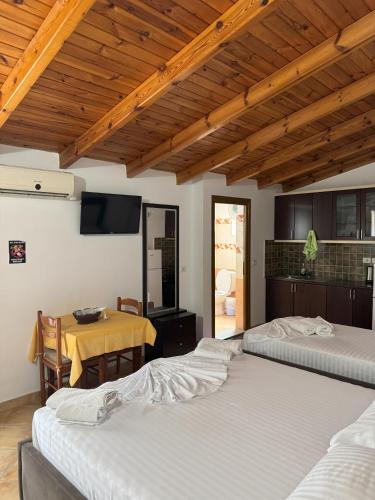 a room with four beds and a table with a television at Garden Villa Veli in Ksamil