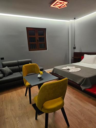 a bedroom with a bed and a table and chairs at Villa Kristiano 21 in Sarandë