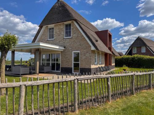 an old house with a fence at Villa by Tjeukemeer with Sauna & Whirlpool in Delfstrahuizen