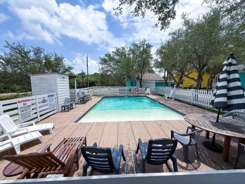 una piscina con sedie, tavolo e ombrellone di Going Coconuts By The Pool a Rockport