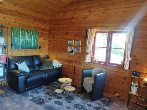 a living room with a leather couch and a table at Weitblicken - Cosy Holiday Home with stunning views in Vradal