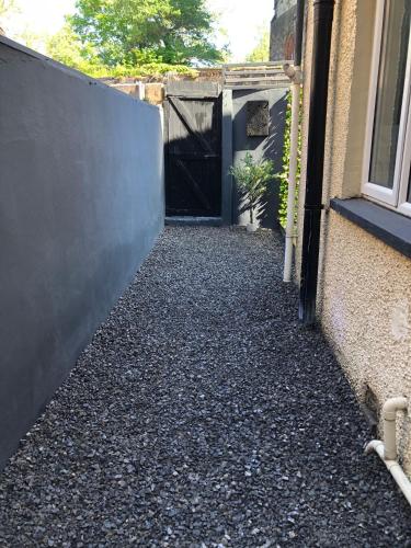 a driveway with a black fence next to a building at Luxury townhouse in Workington in Workington