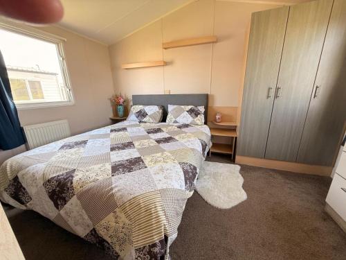 ein Schlafzimmer mit einem Bett mit einer Steppdecke darauf in der Unterkunft Sea Bliss Beachfront Caravan, 2 Bed King Ensuite, Sleeps 6, Wrap Decking, Crimdon Dene in Hartlepool