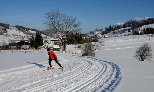 a man is skiing down a snow covered slope at Embacherhof in Embach