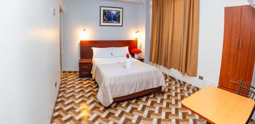 a hotel room with a bed with a vase on it at Hotel Mayros in Satipo