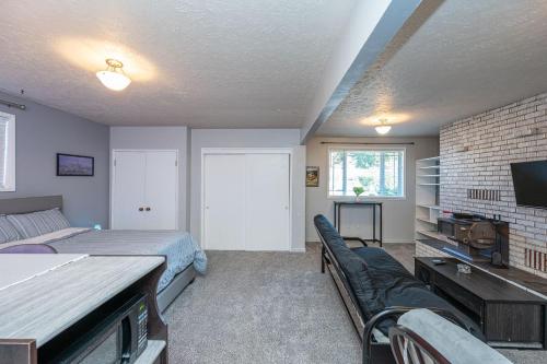 a bedroom with a bed and a couch and a tv at Tranquil Private Studio in Lacey