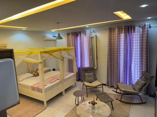 a bedroom with a bed and a table and chairs at Résidence imeris mbour 8 chambres in Dinnguiraye