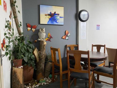 a dining room with a table and butterflies on the wall at Hostel JF in Sao Paulo