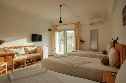 a bedroom with two beds and a table and a couch at La Vida otel in Urla