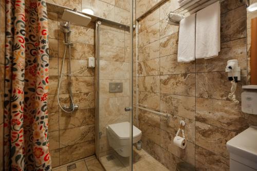 a bathroom with a toilet and a glass shower at La Vida otel in Urla