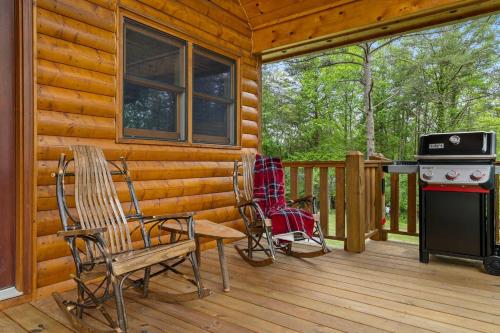 a cabin with two chairs and a stove on a deck at Gentle Ben's Chalet in Murphy