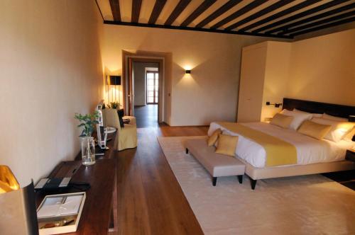 a bedroom with a large bed and a living room at Abadia Retuerta LeDomaine in Sardoncillo