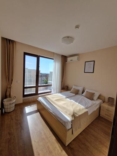 a bedroom with a large bed and a large window at Premier Fort Beach Apartment with Pool & Sea View in Sveti Vlas