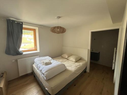 une petite chambre avec un lit blanc et une fenêtre dans l'établissement Apparemment neuf centre ville, à Brives-Charensac