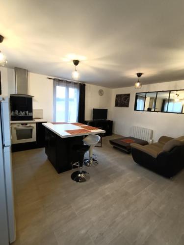 une cuisine et un salon avec une table et un canapé dans l'établissement Le Petit Gîte de l'Eminence, à Clécy