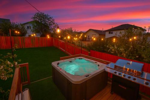 a hot tub in a backyard at night at Spa Oasis Home - Hot Tub - King Bed - BBQ - Garage - Pets! in Edmonton
