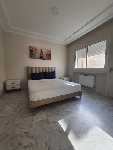 Schlafzimmer mit einem Bett und einem Fenster in der Unterkunft Jinene in Sidi Daoud