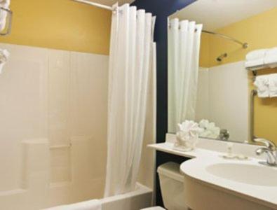 a bathroom with a shower and a toilet and a sink at Microtel Inn & Suites in Dickson City