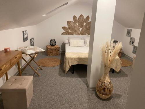 - une chambre avec un lit, une table et un vase dans l'établissement L'échappée belle, à Thaon-les-Vosges