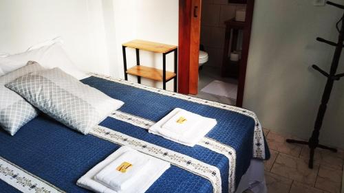 a bed with two towels on top of it at Recanto do Sossego II - Sheriff's House in Santa Cruz do Sul