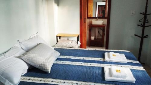 a bedroom with a blue bed with towels on it at Recanto do Sossego II - Sheriff's House in Santa Cruz do Sul