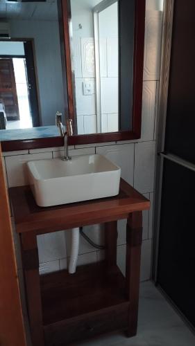 a bathroom with a white sink and a mirror at Recanto do Sossego II - Sheriff's House in Santa Cruz do Sul