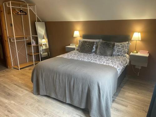 a bedroom with a large bed with two night stands at Wind Rose Rooms in Ballycastle