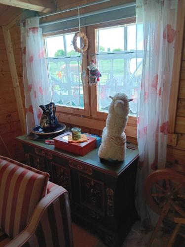 a statue of a sheep sitting on a table in front of a window at Sonnenscheinhof Alpakas, Alpaka Hütte in Lasbek