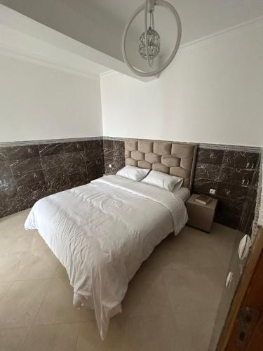 a bedroom with a large bed with a headboard at Homesbybilal in Tangier