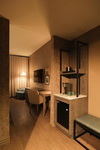 a hotel room with a bed and a dining room at OS Hotel in Ocean Springs