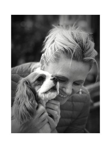 a woman holding a small dog in her hands at MOONTEN Boutique Stay in Sóller