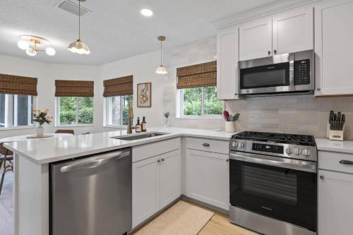 a kitchen with white cabinets and stainless steel appliances at Paradise Shores Pool Home in Palm Coast
