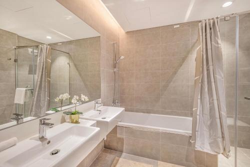 a bathroom with a sink and a tub and a shower at Luxury 2 Bedroom plus kids room Burj Khalifa View in Dubai