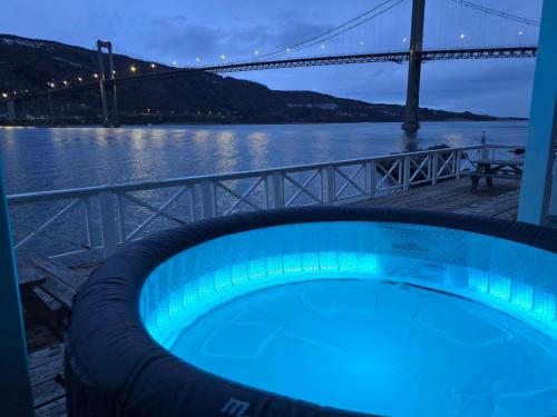 a hot tub with a bridge in the background at Sjøhus ved Tjeldsundet - House by the sea in Evenskjer