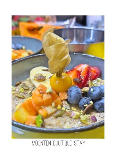a bowl of oatmeal with fruit on top of it at MOONTEN Boutique Stay in Sóller