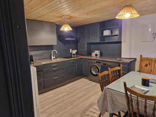 una cucina con armadi blu e un tavolo con tavolo. di Stunning location, Omeath a Ó Méith
